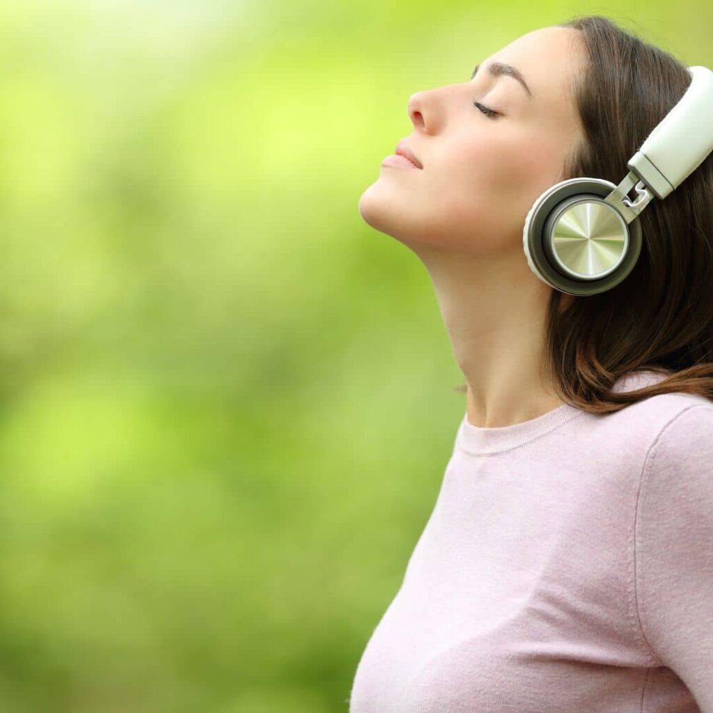 Mujer con auriculares escuchando autohipnosis